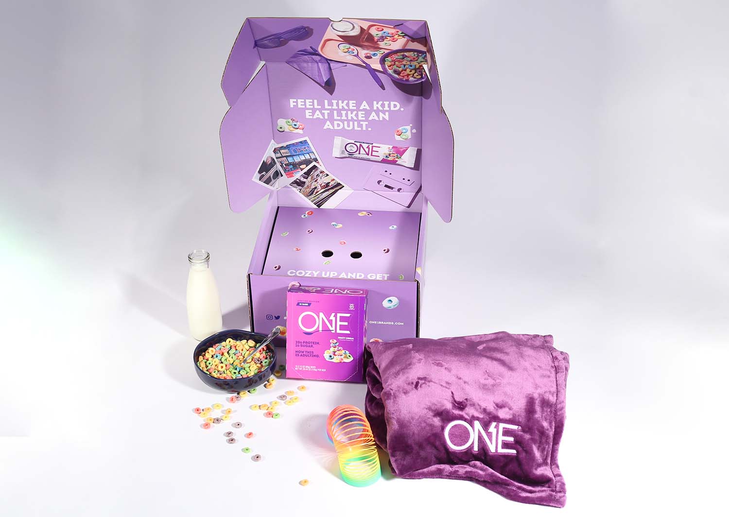 Purple gift box with milk, cereal, blanket and slinky. OneBrands custom mailer box with custom inserts. Fulfillment and drop shipping.